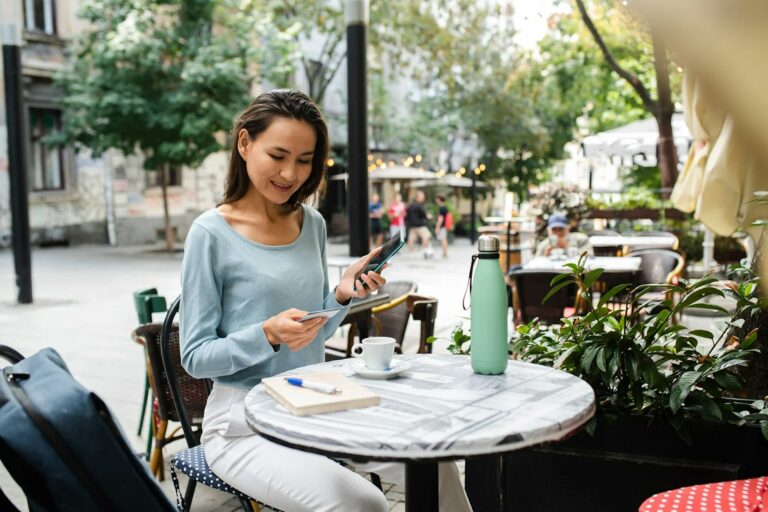 Woman at cafe using smart phone OLELOLE gETTY IMAGES